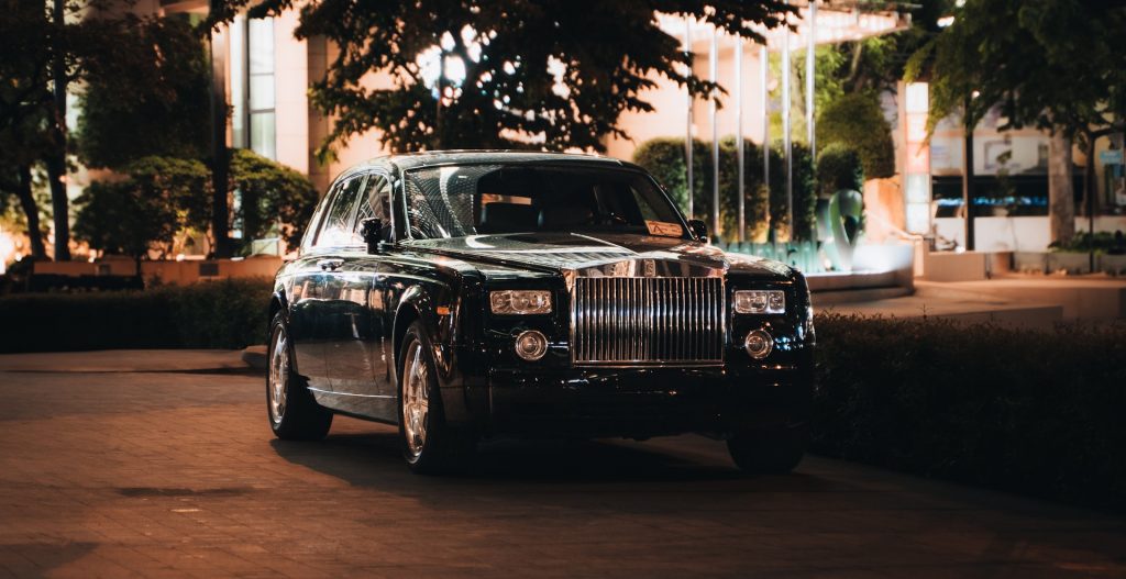 A luxurious black car parked at night.